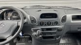 Front interior of a gray Mercedes van, steering wheel on the left, dash with center console and gear shifter visible
