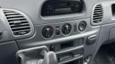 Center console of a vehicle showing a manual gear stick, climate control dials, and a built-in stereo in a Mercedes‑Benz interior