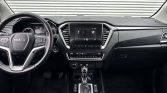 Interior of a modern SUV: steering wheel on the left, center touchscreen, climate controls, gear shifter; black and silver trim.