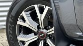 Close-up of a gray Isuzu SUV wheel showing a geometric silver-and-black alloy rim and the ISUZU center cap with a Dunlop Grandtrek tire.