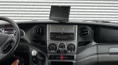 Inside view of an Iveco Daily van cabin with steering wheel, dashboard controls, and a screen mounted on the windshield