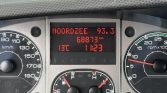 Vehicle dashboard with center display showing Noordzee 93.3 FM, odometer 68,873 km, 13°C, 11:23.