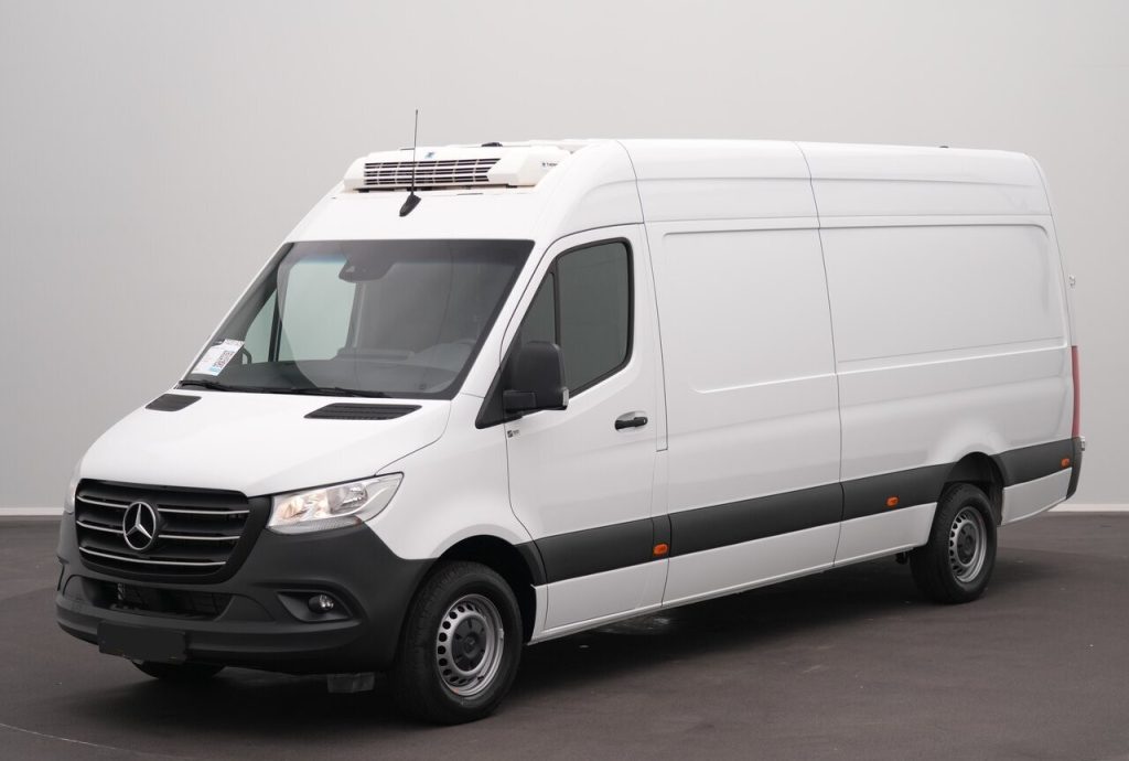 Front three-quarter view of a white Mercedes-Benz cargo van with a rooftop refrigeration unit, parked indoors into a gray background.