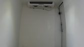 Small utility room with a ceiling-mounted Thermo King air conditioner and exposed cables.