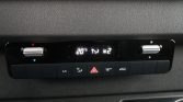 Car climate control panel showing 20°C and passenger temp settings with fan icons and hazard lights button in center