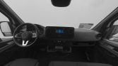 Front cabin of a modern van, showing a steering wheel, digital dashboard, and center touchscreen.