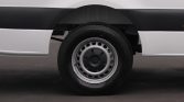 Close-up of a car wheel on a white van, showing a steel rim and black tire.