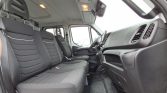 Interior of a cargo van: three front seats, steering wheel, and dashboard visible from a cabin perspective,