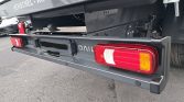 Rear of a gray Henschel-Kipper trailer with a metal bumper and red taillight cluster visible under the body.