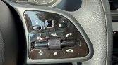 Close-up of car steering wheel controls: home button, back button, volume roller, mute/star, phone buttons.