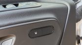 Close-up of a car door panel showing the heated seats button (seat icon with heat waves).