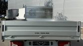 Rear view of a gray steel truck bed with 'STEEL-TRUCK.COM' on the tailgate; red taillights and license plate area visible.