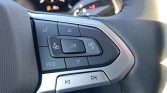 Close-up of steering wheel control cluster: OK button, directional pad, VIEW, and media buttons.