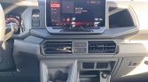 Dashboard interior of a car with a large central touchscreen display above two horizontal air vents and a hazard button in the middle