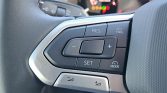Close-up of a car steering wheel's cruise control cluster: RES, CNCL, +, -, SET, and MODE buttons visible.