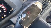 Close-up of an automatic gear shifter with the Park (P) indicator lit and PRND letters around.