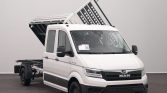 White MAN commercial van with a raised tipping bed, a heavy-duty utility truck ready for loading or unloading materials.