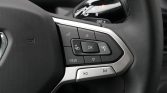 Close-up of a car steering wheel control cluster with an OK button, directional arrows, View label, and phone/volume icons for menu navigation and infotainment control.