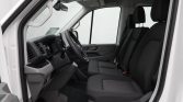 Interior of a white van with the driver’s seat and two front passenger seats, dashboard, and steering wheel. (informative)
