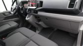 Interior of a car: front seats, steering wheel on the left, and a central touchscreen display on the dashboard.