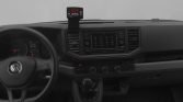 Interior view of a vehicle dashboard featuring steering wheel, gear lever, and a center touchscreen infotainment system with a mounted device on the dash