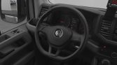Interior of a VW van showing steering wheel, dashboard, and gear shifter from the driver's seat perspective