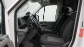 Front interior of a white van: driver and passenger seats, Steering wheel, dashboard, and open door view from the passenger side