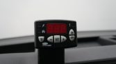 In-car control unit with a red LED display and white buttons mounted on the dashboard strap
