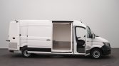 White cargo van with its side door open, revealing an empty metal-floored cargo area inside, on a plain backdrop.