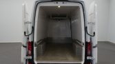 Open white cargo van with empty refrigerated-like interior, diamond-plate wheel wells, and a small ceiling light