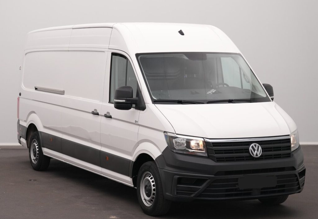 White Volkswagen cargo van, front-right view parked indoors, showing side panel and black bumper