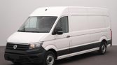 White VW cargo van with a high roof parked in a studio setting, shown from the front-left angle.