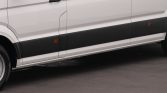 Side view of a white van with black lower body cladding and orange side marker lights on the door area, resting on pavement.
