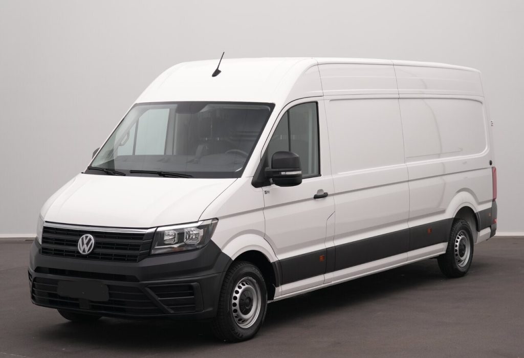 White Volkswagen cargo van shown from a front-side angle in a studio setting, featuring a black bumper and grille and no visible branding other than the VW emblem on the grille.