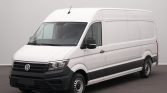 White Volkswagen cargo van shown from a front-side angle in a studio setting, featuring a black bumper and grille and no visible branding other than the VW emblem on the grille.