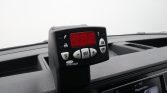 Dashboard interior showing a mounted Carrier TransICOLD digital controller with a red LED display and white buttons near the infotainment screen on the right side of the dash.