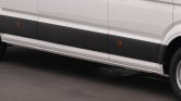 Side view of a white cargo van with a black lower panel and orange reflectors.