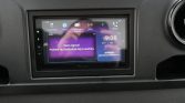 Dashboard touchscreen showing DAB radio app on a Pioneer unit in a Sprinter; message reads 'Geen signaal Probeer de Stationlijst bij te werken' (no signal, update station list). Tijd 9:38, datum 29/1 Do, blurred purple UI.