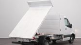 White delivery/utility van equipped with a hydraulically lifted flatbed for dumping cargo.