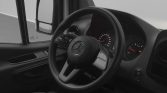Driver’s cockpit in a Mercedes van: steering wheel with logo and illuminated gauge cluster