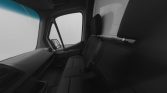 Interior of a van cabin seen from the passenger seat, showing the front dashboard, bench-style rear seating, and side door with a mirror visible through the open window (black-and-white with a blue tint on the windshield).