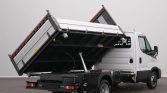White cab truck with a raised hydraulic dump bed, ready to unload cargo
