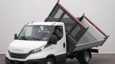 White Iveco tipper truck with its cargo bed raised for unloading, shown from the front-left in a studio setting