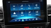 Car infotainment touchscreen showing app tiles: Radio, Media, Telefoon, Apple CarPlay, Android Auto, Voertuig, Klimaat, Camera.