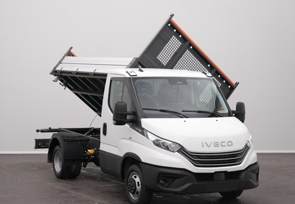 White Iveco dump truck with a raised tipping bed in a studio setting, front view showing the cab and orange edge on the bed.
