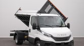 White Iveco dump truck with a raised tipping bed in a studio setting, front view showing the cab and orange edge on the bed.