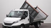 White IVECO dump truck with its metal cargo bed raised, ready to dump gravel or debris in an indoor setting