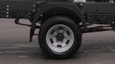 Rear truck wheel and undercarriage with exhaust pipe visible on the right side.