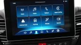 Infotainment touchscreen home screen in a car showing eight blue tiles: Radio, Media, Telefoon, Apple CarPlay, Android Auto, Voertuig, Klimaat, Camera.