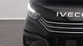 Front-left close-up of a black Iveco van showing the illuminated headlight and chrome grille